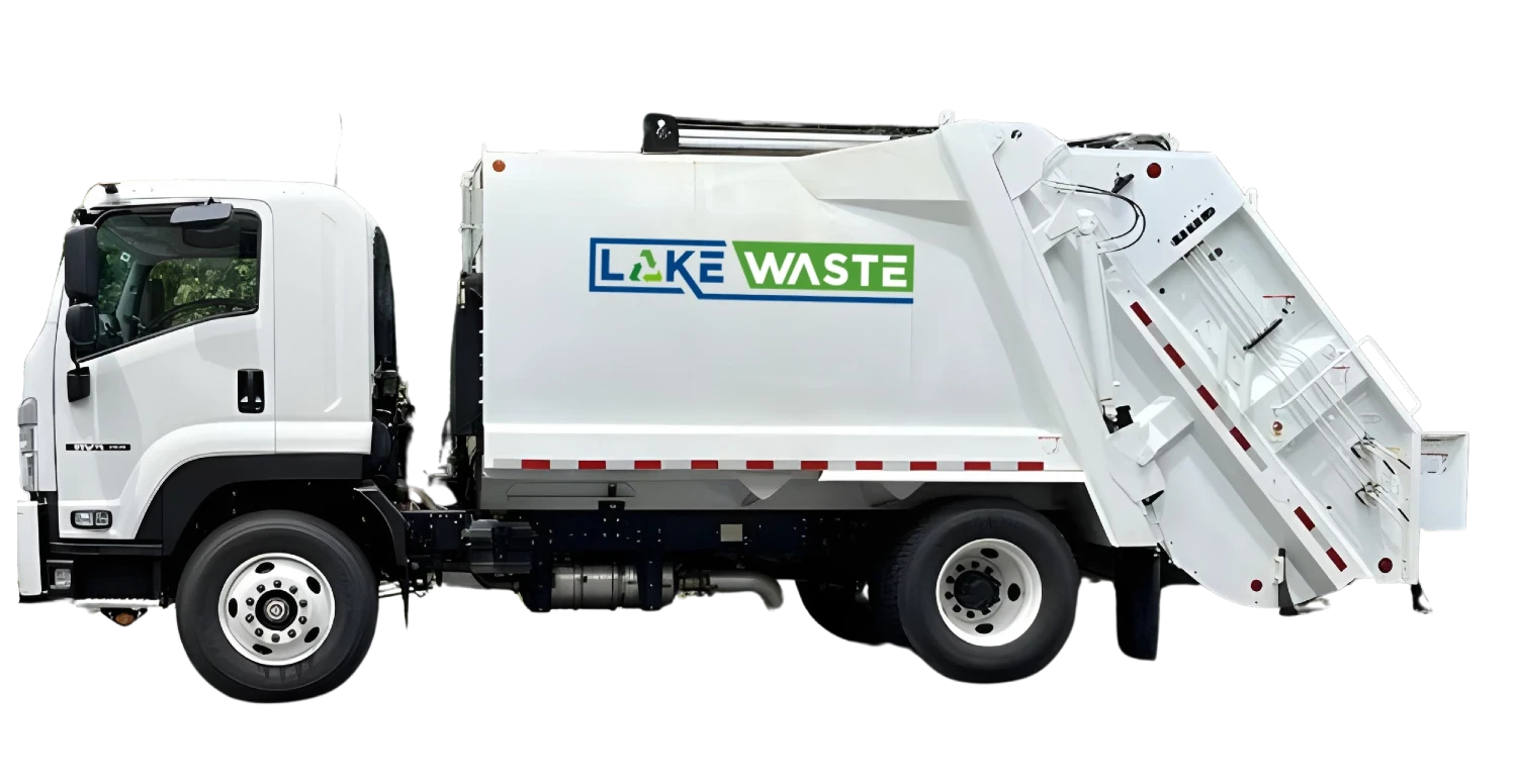 A waste collection vehicle marked with "Lake Waste," actively engaged in garbage collection on a residential street.